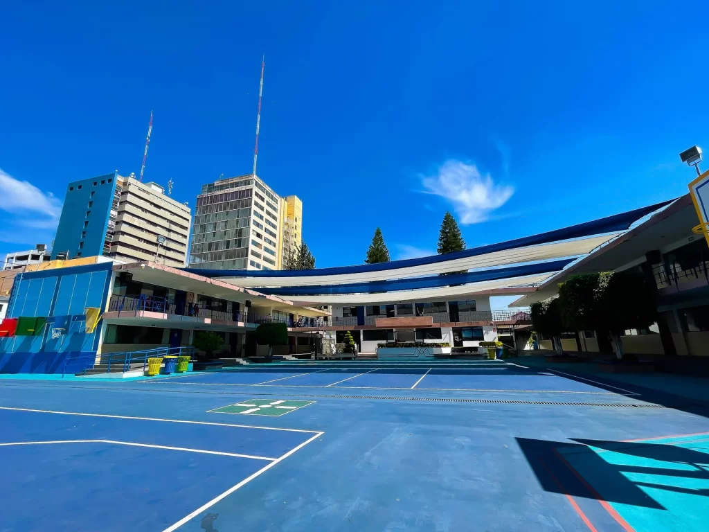 Patio y canchas de la primaria con los edificios del colegio al fondo